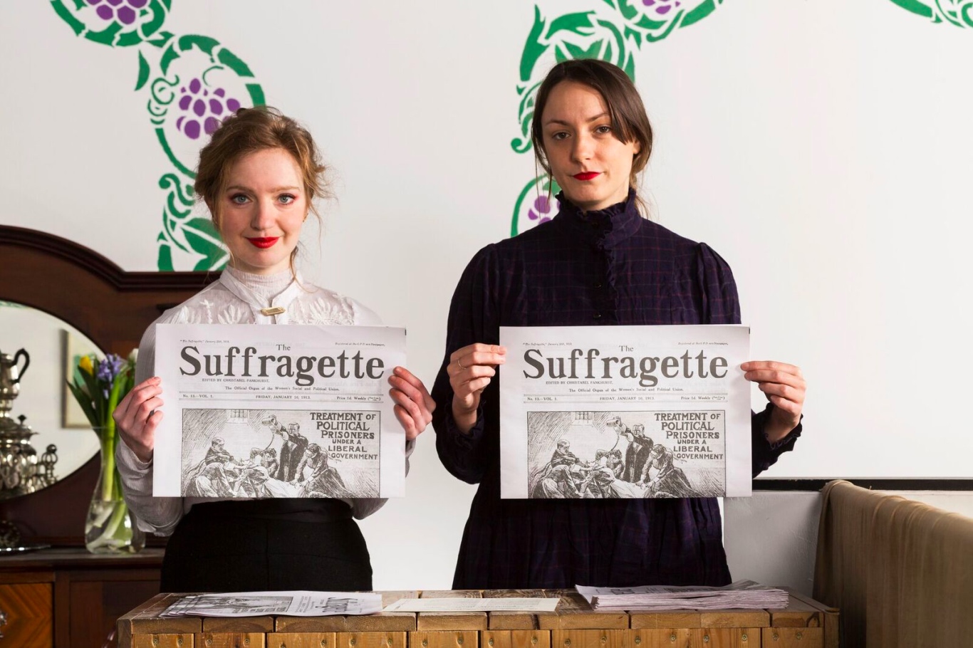 suffragettes holding newspapers
